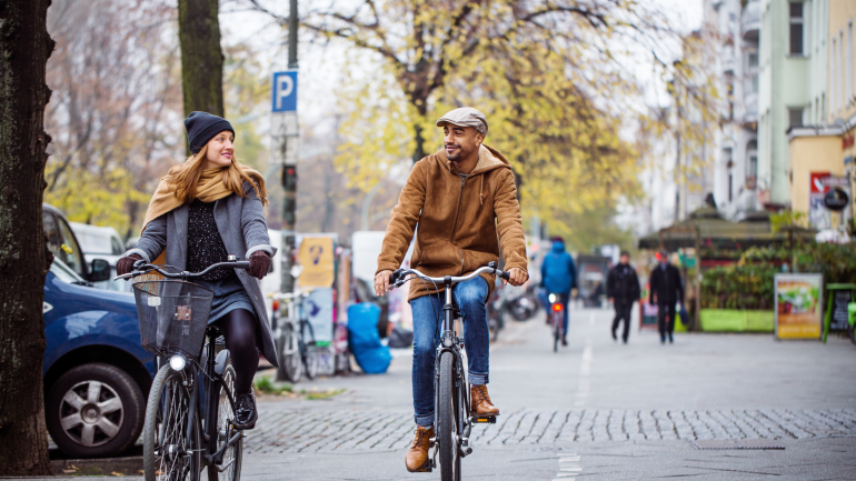 Ein Pärchen fährt gemeinsam auf zwei Fahrrädern durch die Stadt