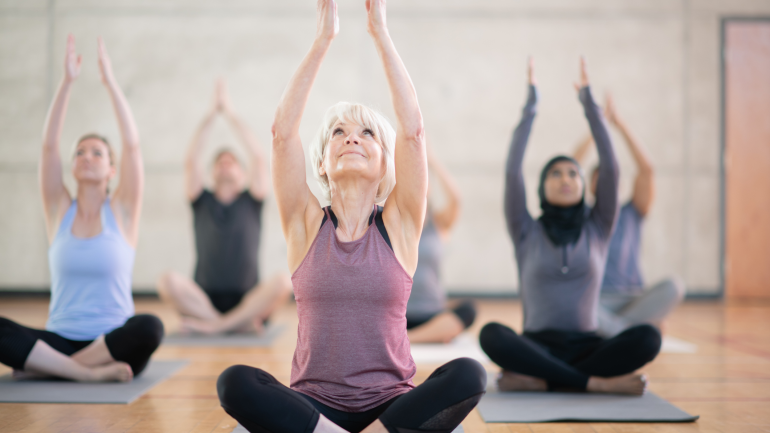 Eine Gruppe von Frauen macht gemeinsam Yoga in einem Kurs